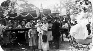 In the foreground, Mrs. Martha Weber, wife of Rev. Paul C. Weber of Epiphany Evangelical Lutheran Church, holds boy Carl W. Weber, with daughter Katherine by her side. July 4, 1923.