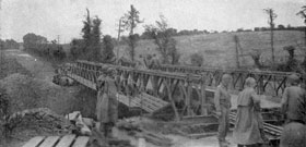 Men of the 12th Combat Engineer Battalion complete a Bailey Bridge over a ravine near Lambzellec, France, on the road to Brest.