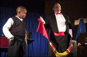 A child vanishes and reappears a mult-color handkerchief.
